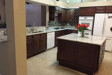 Inspiration for a large timeless u-shaped ceramic tile open concept kitchen remodel in Tampa with an undermount sink, raised-panel cabinets, medium tone wood cabinets, granite countertops, white appliances and an island
