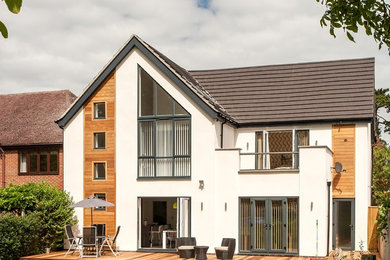 This is an example of a white modern render house exterior in Other with a pitched roof.