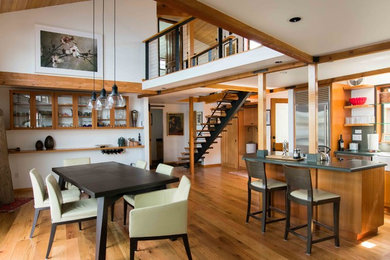 Example of a large minimalist medium tone wood floor and brown floor great room design in Seattle with white walls