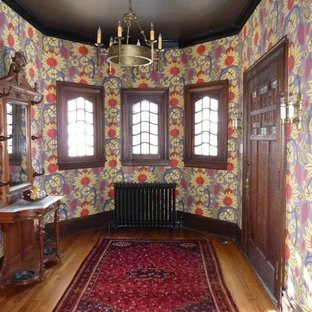 Inredning av en eklektisk mellanstor ingång och ytterdörr, med flerfärgade väggar, ljust trägolv, en enkeldörr, en brun dörr och brunt golv