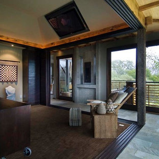 Esempio di una grande camera matrimoniale etnica con pareti verdi, moquette, camino lineare Ribbon e cornice del camino in pietra