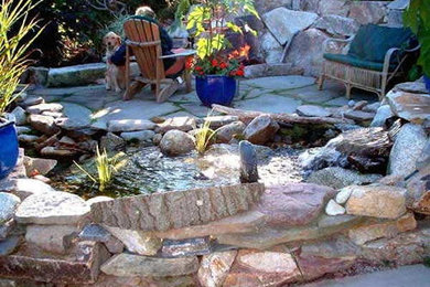 Inspiration for a mid-sized tropical partial sun backyard stone landscaping in Portland Maine for summer.