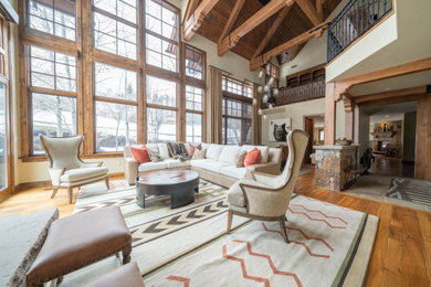 Foto de salón tipo loft moderno grande sin televisor con paredes beige, suelo de madera en tonos medios, suelo marrón y vigas vistas