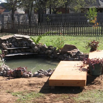 Coy pond, rock waterfall with a small bridge deck.