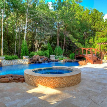Natural Pool with rock waterfall, bridge, spa, and pergola