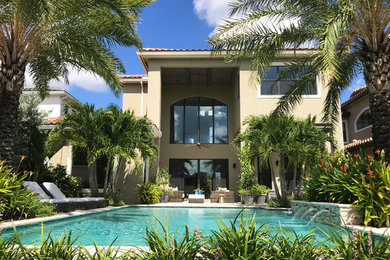 Photo of a mid-sized tropical backyard full sun formal garden in Miami with natural stone pavers.
