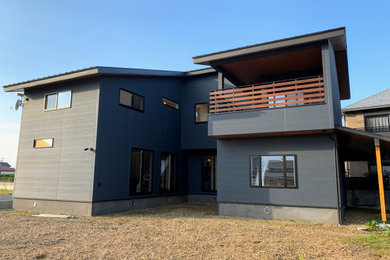 Modelo de fachada de casa gris y negra de estilo zen de dos plantas con revestimientos combinados, tejado de un solo tendido y tejado de metal
