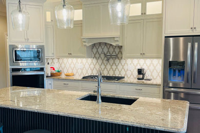 Large transitional single-wall vinyl floor, brown floor and tray ceiling eat-in kitchen photo in Other with an undermount sink, shaker cabinets, black cabinets, granite countertops, multicolored backsplash, marble backsplash, stainless steel appliances, an island and multicolored countertops