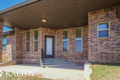 Mid-sized traditional one-story brick exterior home idea in Oklahoma City with a shingle roof