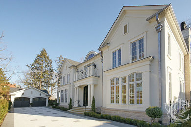 Large elegant white two-story stucco exterior home photo in Toronto with a shingle roof