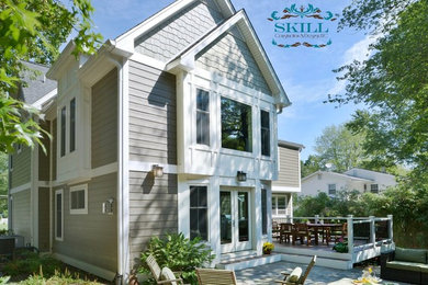 Example of a large minimalist gray two-story concrete fiberboard exterior home design in DC Metro with a gambrel roof