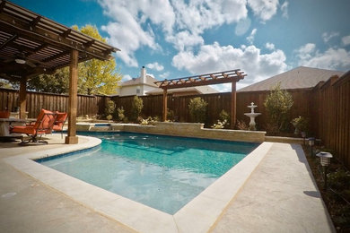 Mid-sized mediterranean backyard custom-shaped natural pool in Dallas with a hot tub and stamped concrete.