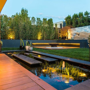 Contemporary full sun garden in Melbourne with with pond and decking.