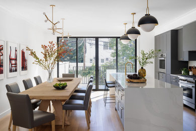 Large transitional galley light wood floor and brown floor eat-in kitchen photo in New York with an undermount sink, shaker cabinets, dark wood cabinets, quartz countertops, white backsplash, stone slab backsplash, stainless steel appliances, two islands and white countertops