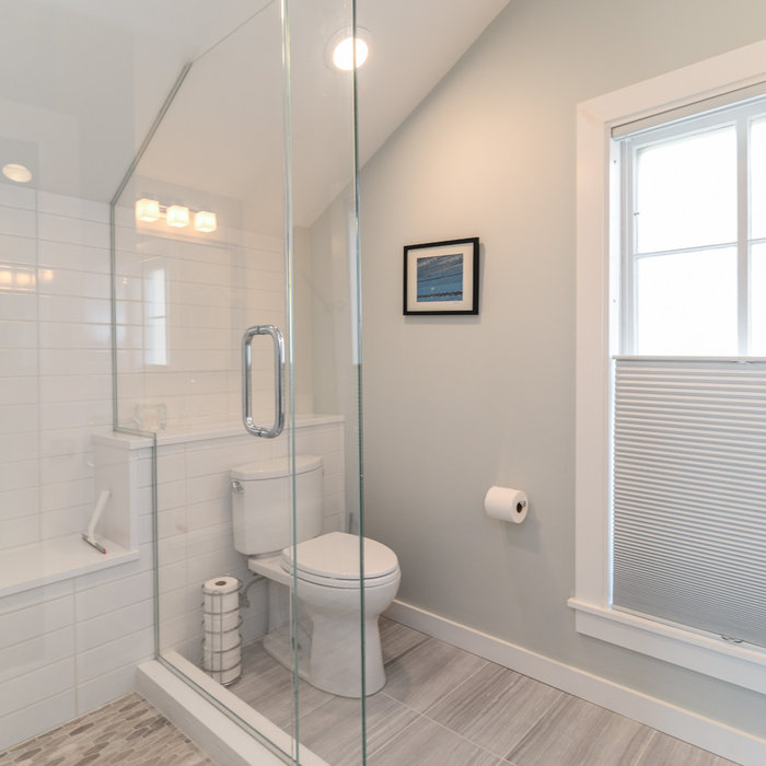 The loft bathroom packs a lot in to a smaller space. The wall tile runs the length of the bathroom to create a larger appearance, plumbing is hidden in a shelf/ledge created with a waterfall edge of q