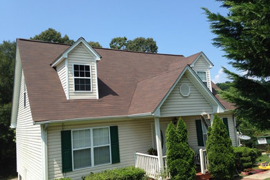 Ejemplo de fachada de casa beige clásica pequeña de dos plantas con revestimiento de vinilo, tejado a dos aguas y tejado de teja de madera