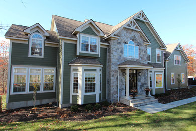 Inspiration for a large timeless green two-story wood exterior home remodel in New York with a shingle roof