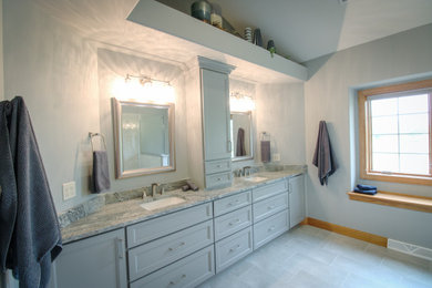 Inspiration for a large transitional master gray tile and porcelain tile porcelain tile, gray floor and double-sink shower bench remodel in Milwaukee with shaker cabinets, gray cabinets, a one-piece toilet, gray walls, an undermount sink, granite countertops, a hinged shower door, multicolored countertops and a built-in vanity