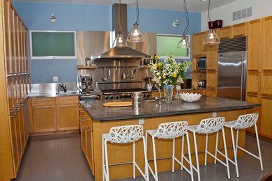 Mid-sized trendy u-shaped concrete floor eat-in kitchen photo in DC Metro with an undermount sink, recessed-panel cabinets, medium tone wood cabinets, stainless steel countertops, metallic backsplash, stainless steel appliances and an island