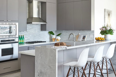 Mid-sized contemporary u-shaped kitchen in Toronto with flat-panel cabinets, grey cabinets, granite benchtops, grey splashback, stone tile splashback, stainless steel appliances, porcelain floors and a peninsula.