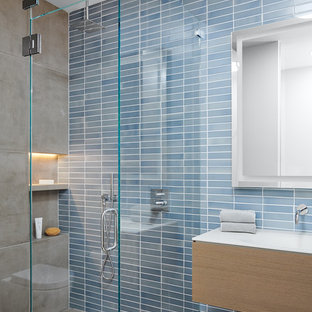 Idee per una stanza da bagno moderna con ante lisce, ante in legno scuro, doccia ad angolo, piastrelle blu, lavabo integrato, pavimento grigio, porta doccia a battente e top bianco