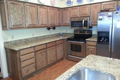 Inspiration for a mid-sized timeless u-shaped medium tone wood floor and brown floor eat-in kitchen remodel in Nashville with an undermount sink, raised-panel cabinets, light wood cabinets, granite countertops, stainless steel appliances and a peninsula