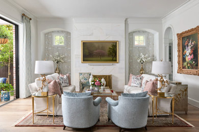 Example of a large classic open concept light wood floor, brown floor and wallpaper living room design in Houston with white walls, a standard fireplace, a wall-mounted tv and a tile fireplace