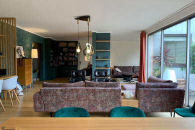 Exemple d'une grande salle de séjour éclectique ouverte avec une bibliothèque ou un coin lecture, un mur multicolore, parquet clair, un poêle à bois, un téléviseur dissimulé et du papier peint.