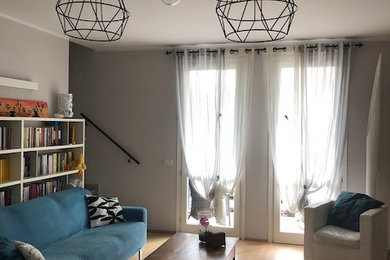 Immagine di un soggiorno contemporaneo con pareti grigie e parquet chiaro