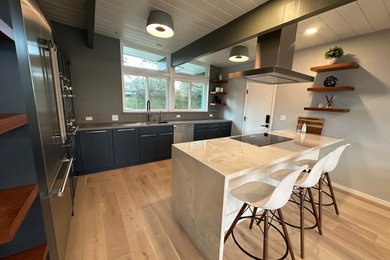 Inspiration for a mid-sized contemporary l-shaped light wood floor, beige floor and exposed beam open concept kitchen remodel in San Francisco with a single-bowl sink, flat-panel cabinets, blue cabinets, quartzite countertops, gray backsplash, stainless steel appliances, an island and multicolored countertops