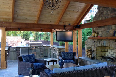 Large arts and crafts backyard stone patio kitchen photo in Richmond with a gazebo