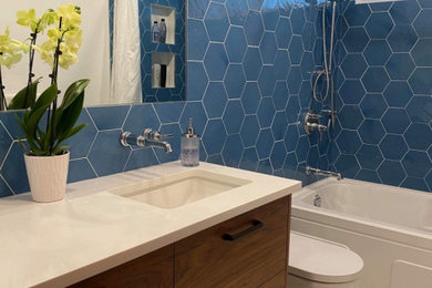 Inspiration for a mid-sized modern blue tile and porcelain tile porcelain tile, white floor and single-sink bathroom remodel in Calgary with flat-panel cabinets, dark wood cabinets, a one-piece toilet, white walls, an integrated sink, quartz countertops, white countertops, a niche and a floating vanity
