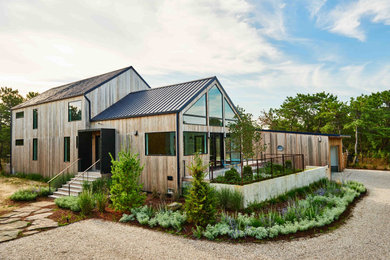 Contemporary two-story wood exterior home idea in New York with a metal roof