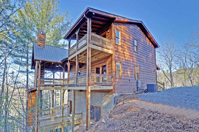 Mid-sized mountain style brown three-story wood exterior home photo in Atlanta with a metal roof