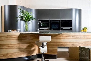 Design ideas for a contemporary open plan kitchen in Other with a submerged sink, flat-panel cabinets, light wood cabinets, marble worktops and black appliances.