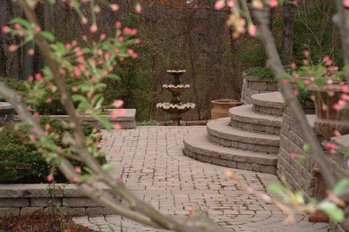 Photo of a large traditional partial sun backyard brick landscaping in Other.