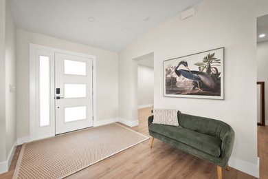 Entryway - mid-sized coastal light wood floor, beige floor, shiplap ceiling and wood wall entryway idea in Orlando with white walls and a white front door