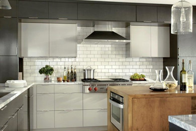 Inspiration for a contemporary kitchen remodel in St Louis with an undermount sink, gray cabinets, white backsplash, subway tile backsplash, paneled appliances and an island