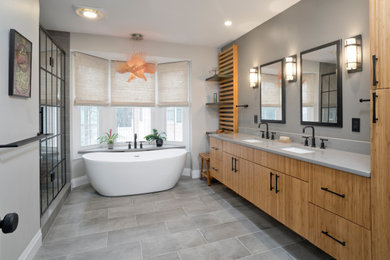 Design ideas for a large contemporary master bathroom in DC Metro with flat-panel cabinets, light wood cabinets, a freestanding tub, an alcove shower, a one-piece toilet, gray tile, porcelain tile, grey walls, porcelain floors, an undermount sink, engineered quartz benchtops, grey floor, a hinged shower door, grey benchtops, a niche, a double vanity and a floating vanity.