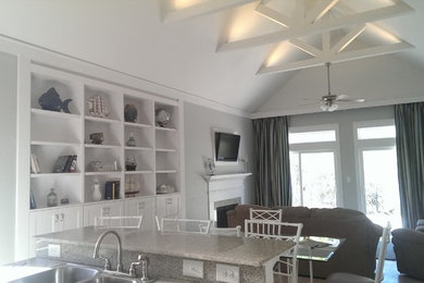 Example of a beach style family room design in Miami with a standard fireplace