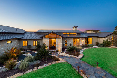 Example of a huge trendy multicolored one-story stone exterior home design in Austin with a metal roof