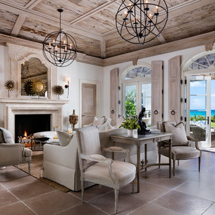 Imagen de salón para visitas abierto, mediterráneo, de tamaño medio, sin televisor, con paredes blancas, chimenea tradicional, marco de chimenea de piedra, suelo de baldosas de cerámica y suelo beige