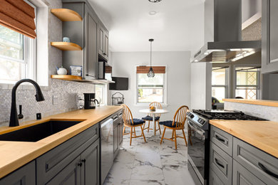 Kitchen - cottage galley kitchen idea in Los Angeles with an undermount sink, raised-panel cabinets, gray cabinets, wood countertops, white backsplash, mosaic tile backsplash and stainless steel appliances