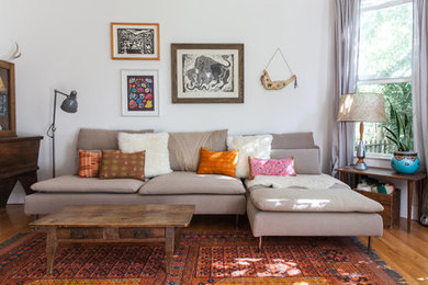 This is an example of an eclectic open concept living room in Sacramento with white walls.