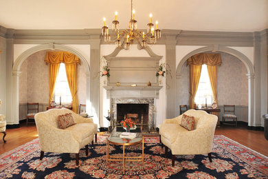 Elegant formal and enclosed dark wood floor and brown floor living room photo in DC Metro with gray walls, a standard fireplace, a stone fireplace and no tv