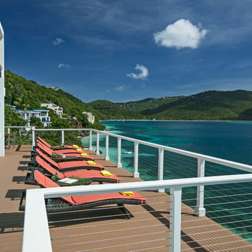 Light blue colored back painted glass panels on the side of an infinity pool wit