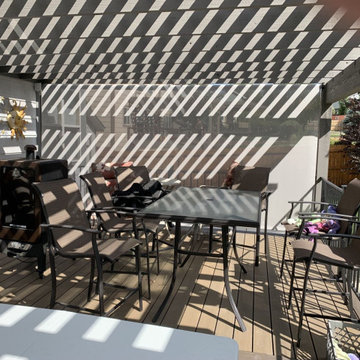 Pergola with a drop down shade creates a private outdoor living area