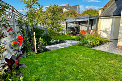 Medium sized modern back garden for summer in London with a wood fence.