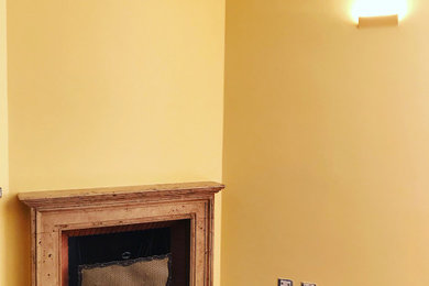 Foto di un soggiorno chic con pareti gialle, pavimento in legno massello medio e camino classico