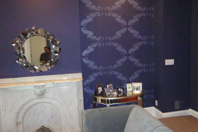 Foto de sala de estar abierta tradicional grande con paredes púrpuras y marco de chimenea de piedra